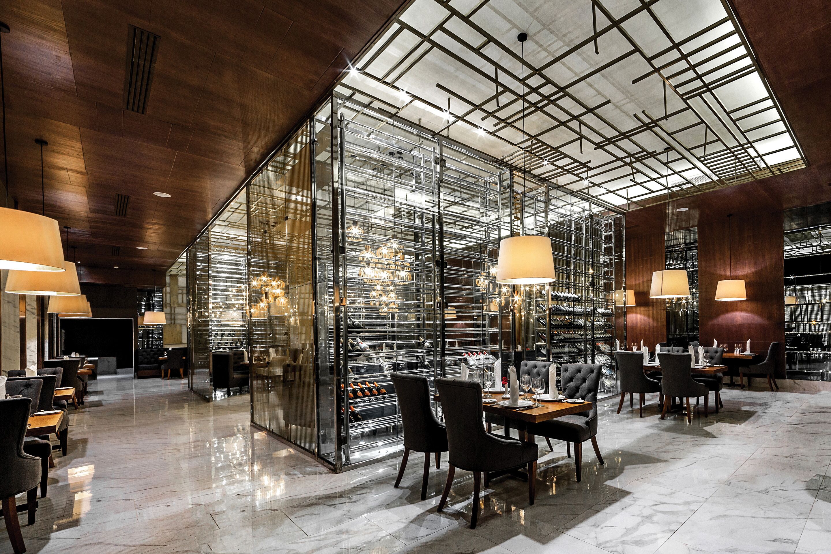 A modern interior with a wine cellar, seating areas, and a skylight.