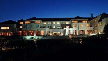 Vista frontal de la propiedad por la tarde o noche