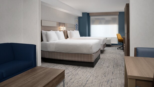 Una habitación de hotel con una cama grande, un sofá, un escritorio y una silla.