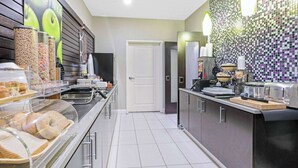 Una cucina moderna con isola per la colazione, distributori automatici di cereali e zoccolo paraschizzi in piastrelle.