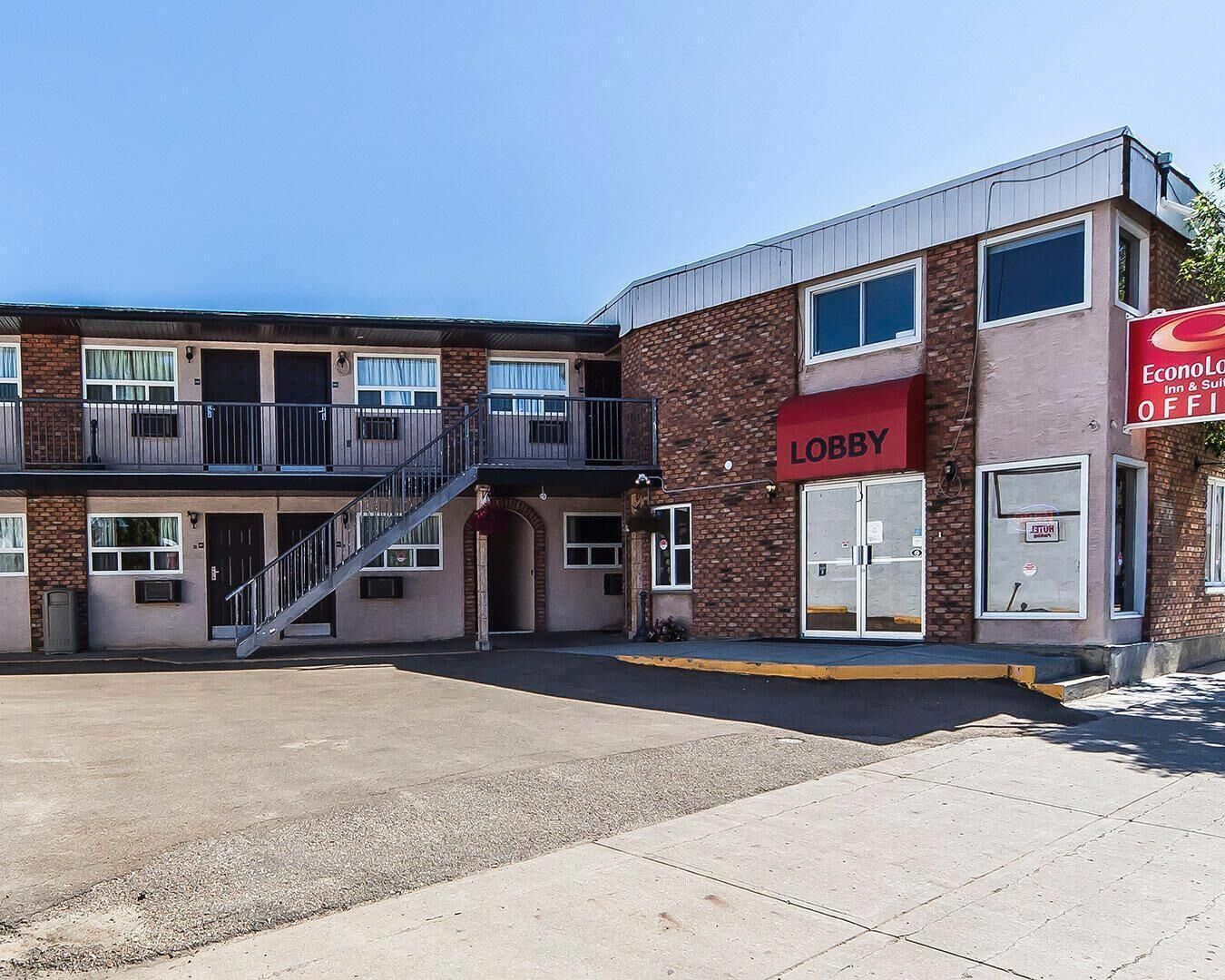 A two-story building with a red awning labeled 'Lobby' and a sign for 'EconoLoft Inn & Suites' indicating an open office space.