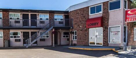A two-story building with a red awning labeled 'Lobby' and a sign for 'EconoLoft Inn & Suites' indicating an open office space.