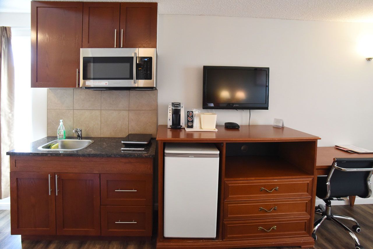 A compact kitchenette with a microwave, coffee maker, and a small refrigerator.
