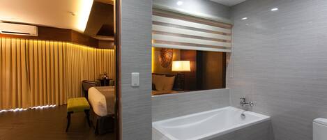 Une salle de bain moderne avec une baignoire, des toilettes et un miroir.
