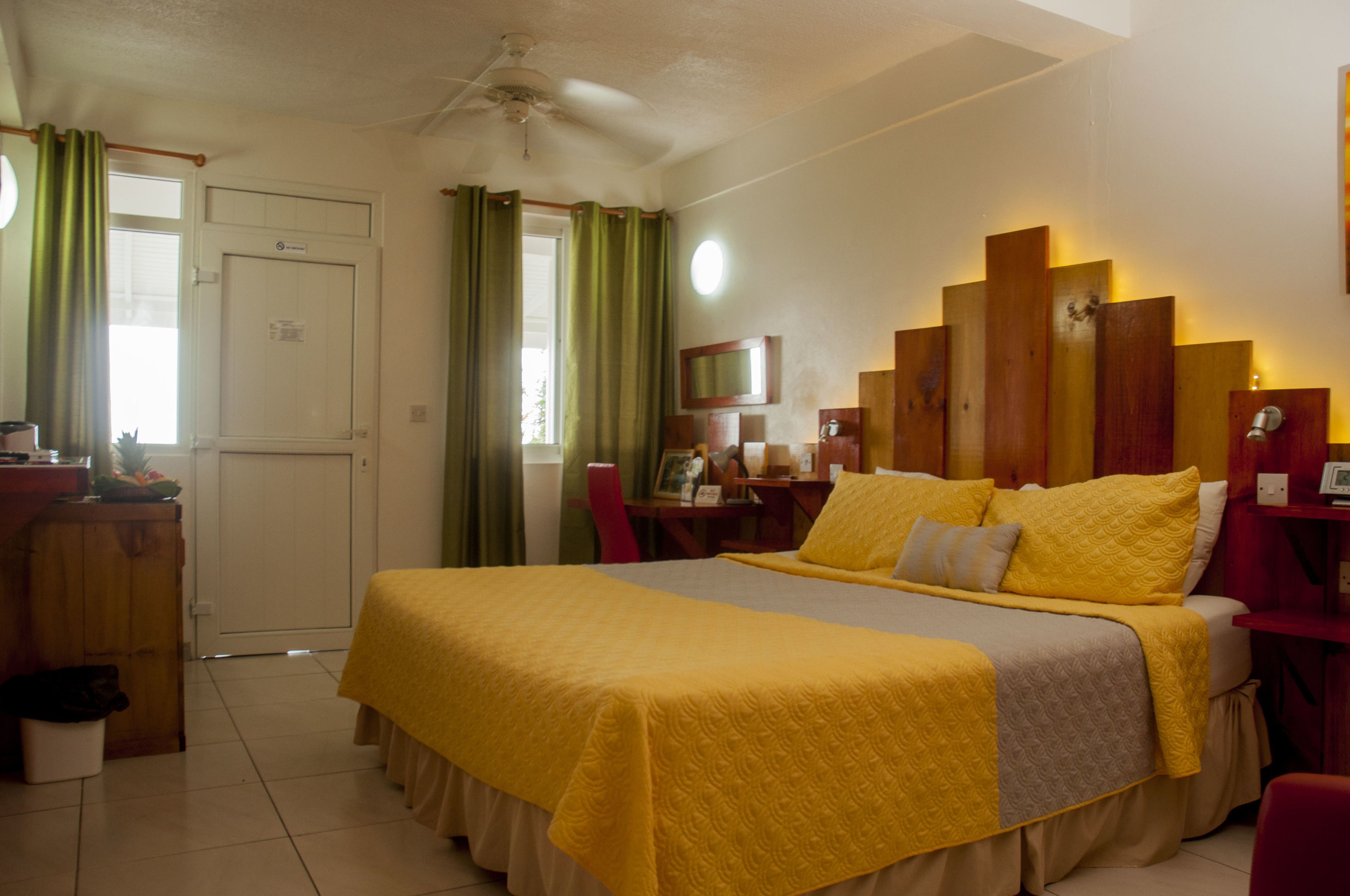 Habitació d'hotel amb un llit, escriptori, cadira, televisió i una porta.