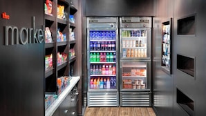 Ein modernes Interieur mit einer Verkaufsmaschine mit dem Aufdruck „the market“ und einer gekühlten Warenpräsentation.