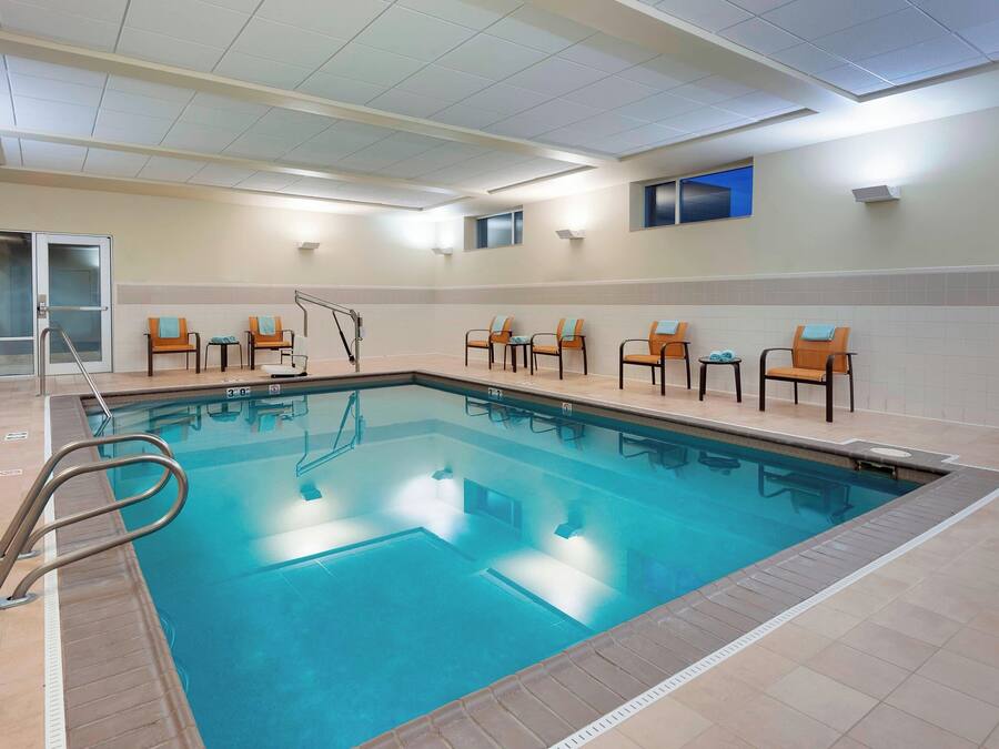 Una piscina con sedie e spogliatoio.