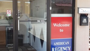 The entrance to the American Regency Inn with a 'Welcome' sign, a 'Key Drop' box, and a 'Pull' sign on the door. - American Regency Inn (Williams)