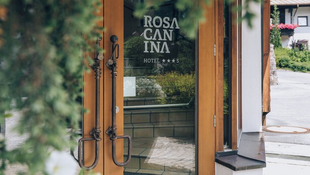 A hotel entrance with a wooden door and a sign that reads "ROSA CANINA HOTEL". - Rosa Canina (Sankt Anton am Arlberg)