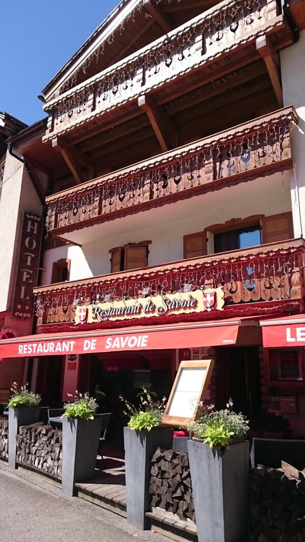 Un edificio con un restaurante llamado "Restaurant de Savoie" en la planta baja.