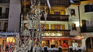 Een gebouw bedekt met sneeuw, met daarin een restaurant genaamd 'Restaurant de Savoie' en een bord met 'Les Airelles'.