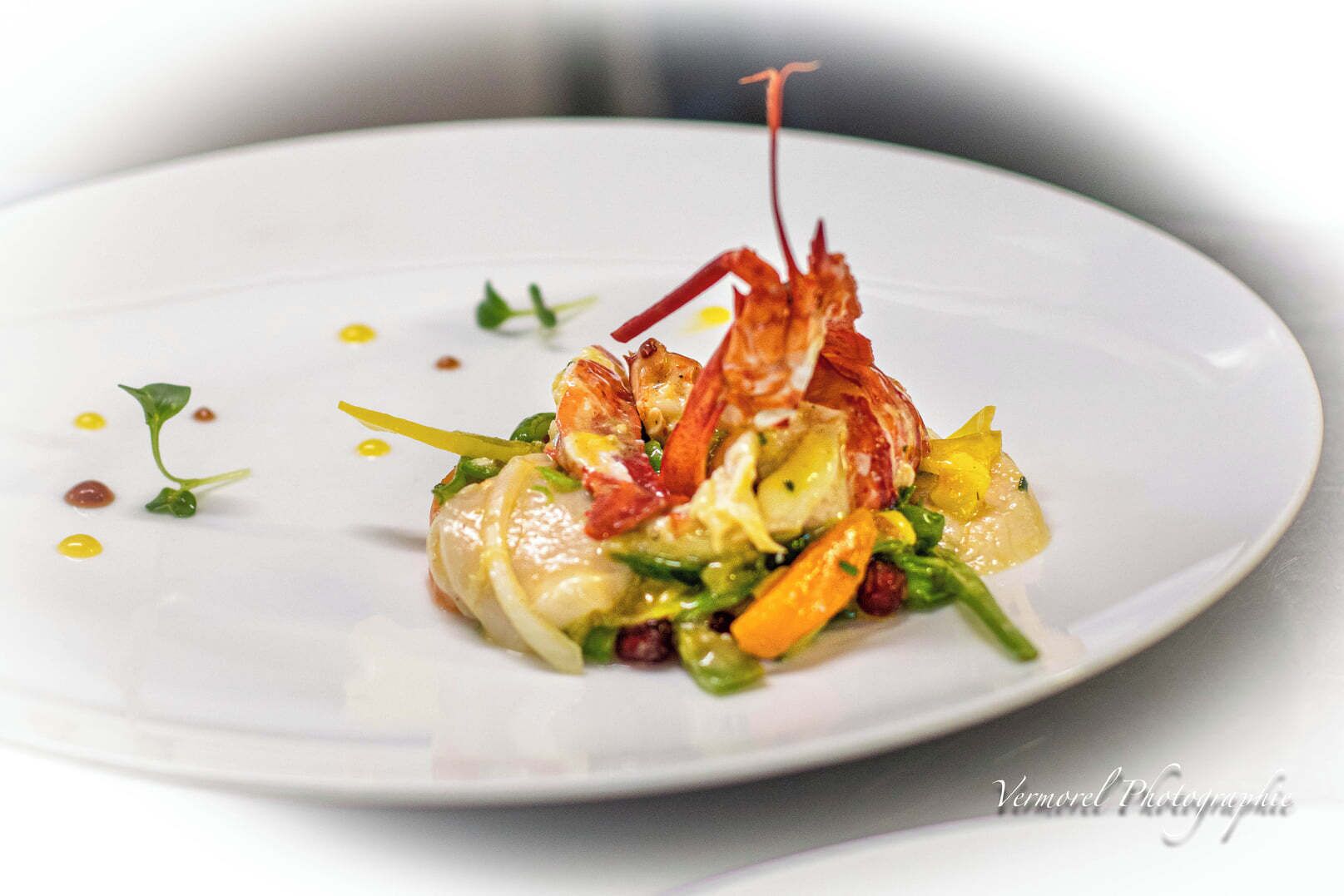 A plate of food with shrimp, vegetables, and a sauce.
