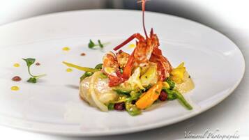A plate of food with shrimp, vegetables, and a sauce.