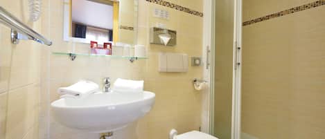 A bathroom with a sink, toilet, and glass-enclosed shower.