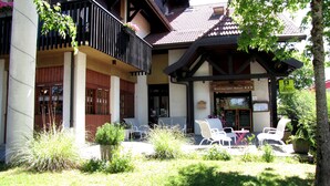 A restaurant-hotel with outdoor seating, a balcony, and a sign indicating it is a logis. - Logis Hôtel Annecy Nord / Argonay (Argonay)