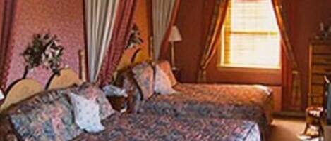 Un dormitorio con dos camas, un aparador y una ventana con cortinas.