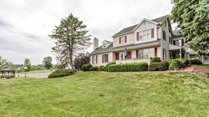 A large two-story house with a well-maintained lawn and a gazebo in the foreground. - West Ridge Bed and Breakfast (Elizabethtown)