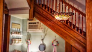 A staircase with a wooden handrail and a stained glass light fixture. - O'Casey's Boutique Inn (San Antonio)