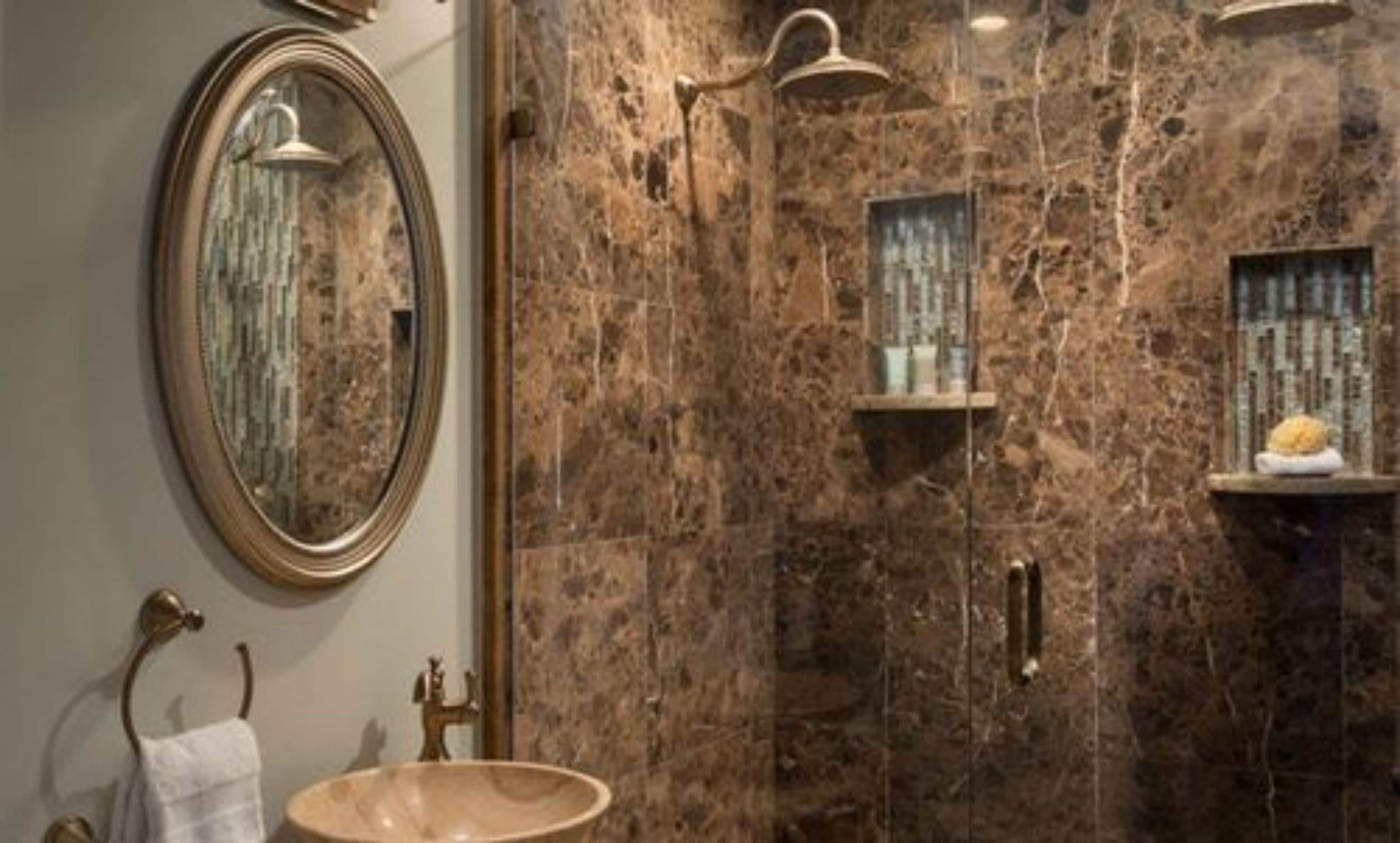 Un baño con pared de mármol, un lavabo redondo, un espejo y un perchero para toallas.