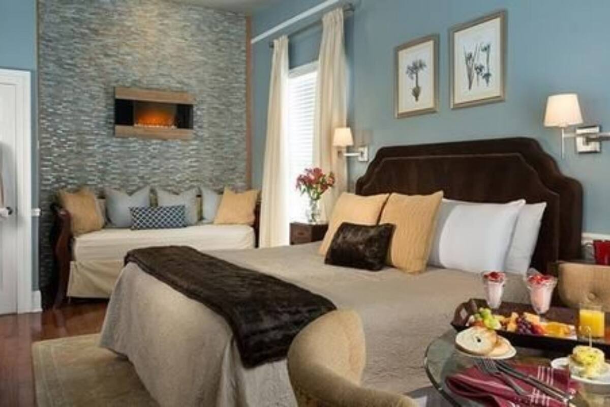 A hotel room with a bed, a nightstand, a lamp, and a breakfast tray on the table.