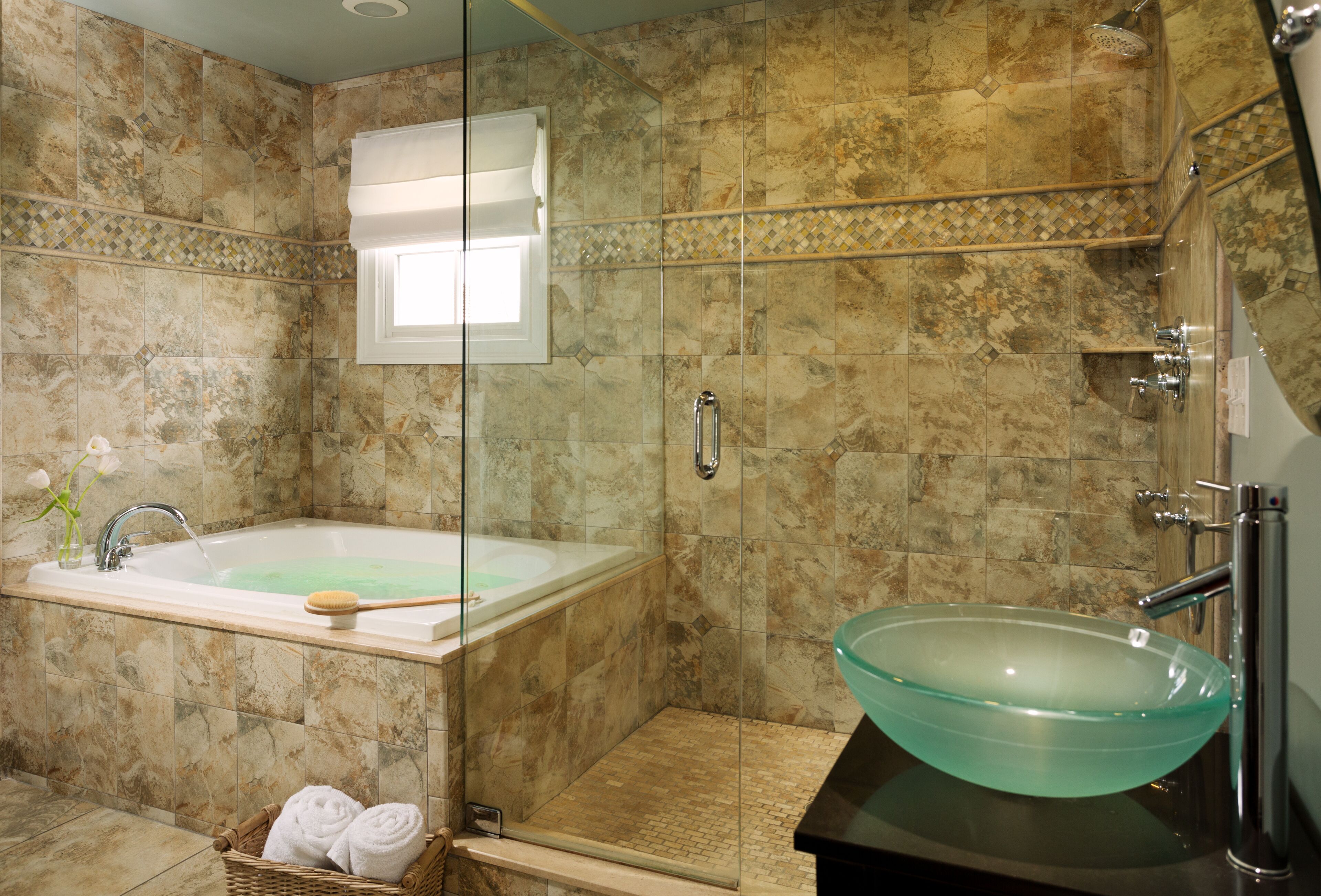 A bathroom with a glass-enclosed shower, a freestanding bathtub, and a vessel sink.