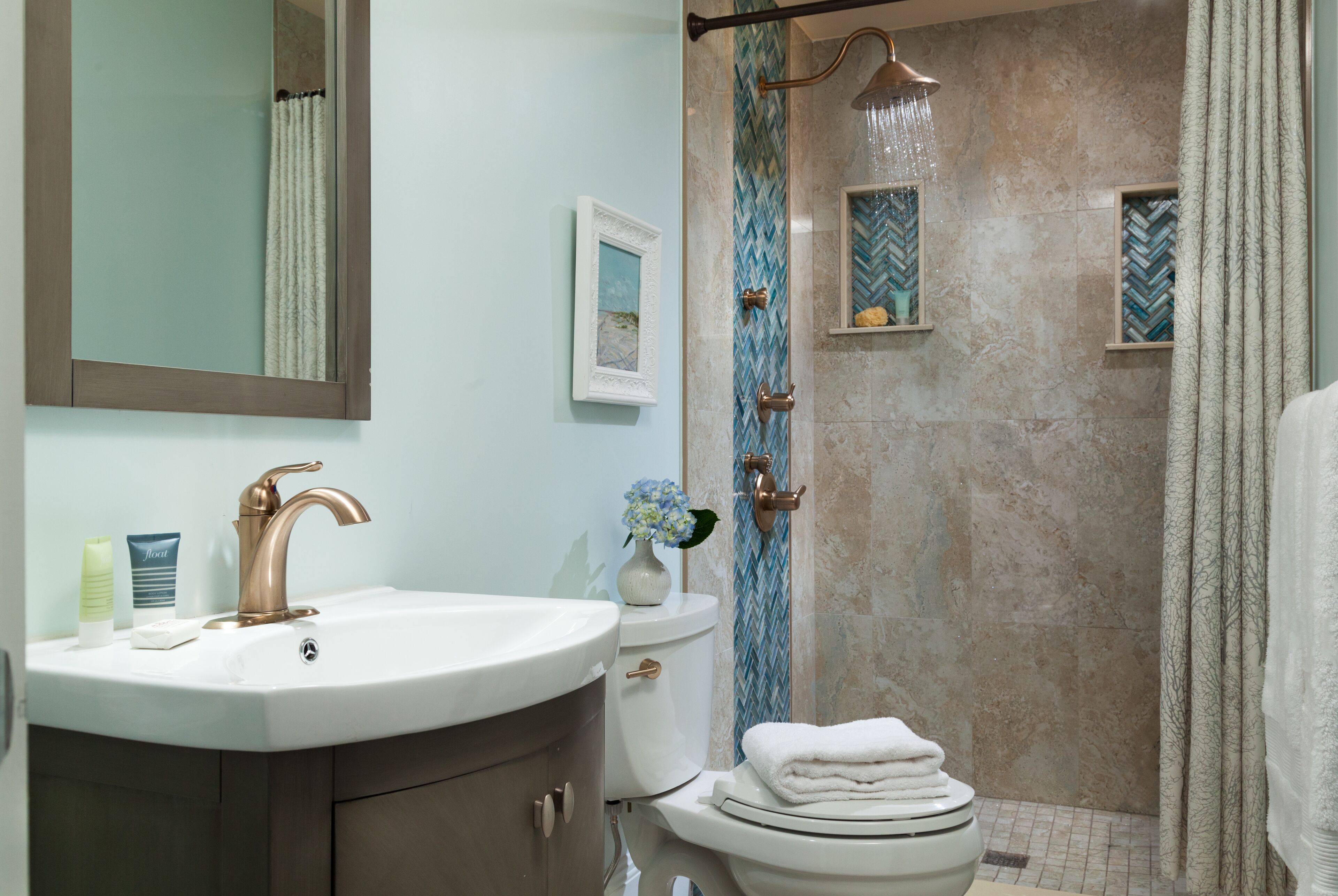 Une salle de bain avec un lavabo, des toilettes et une douche.