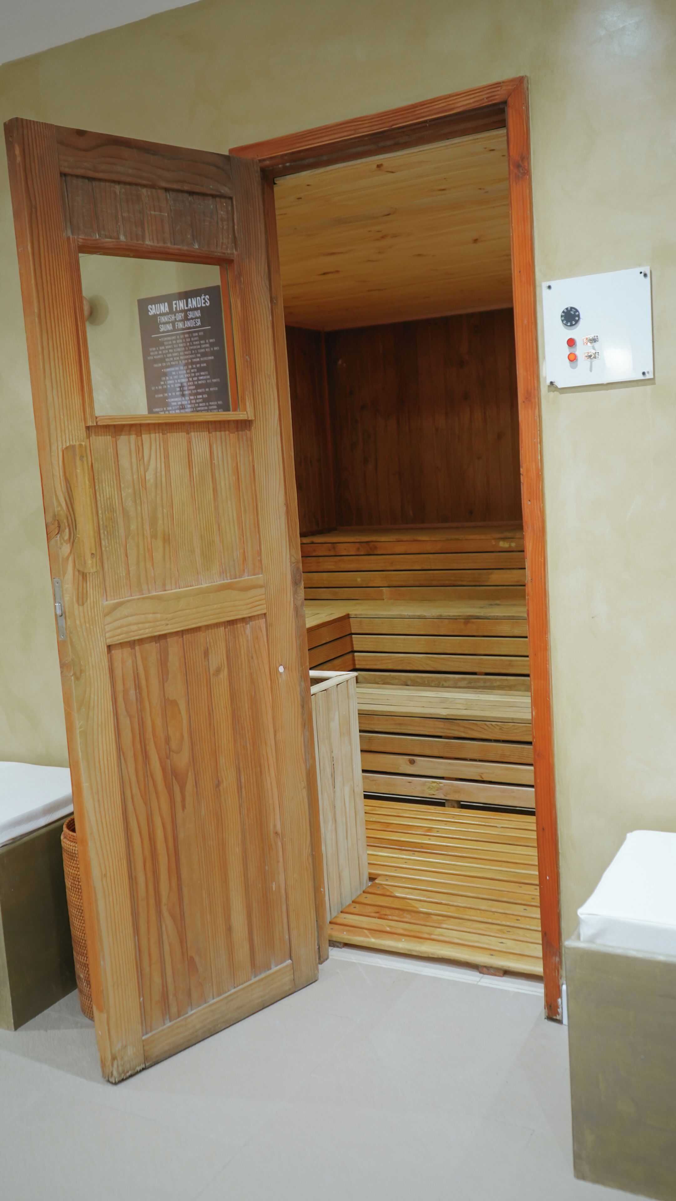 Un sauna con bancos de madera y una puerta con un letrero.