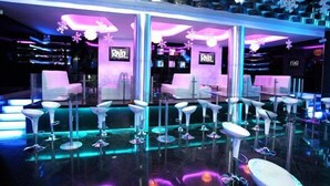 A modern bar area with multiple bar stools and a neon sign. - Sammy Dalat Hotel (Xuan Huong - Da Lat)