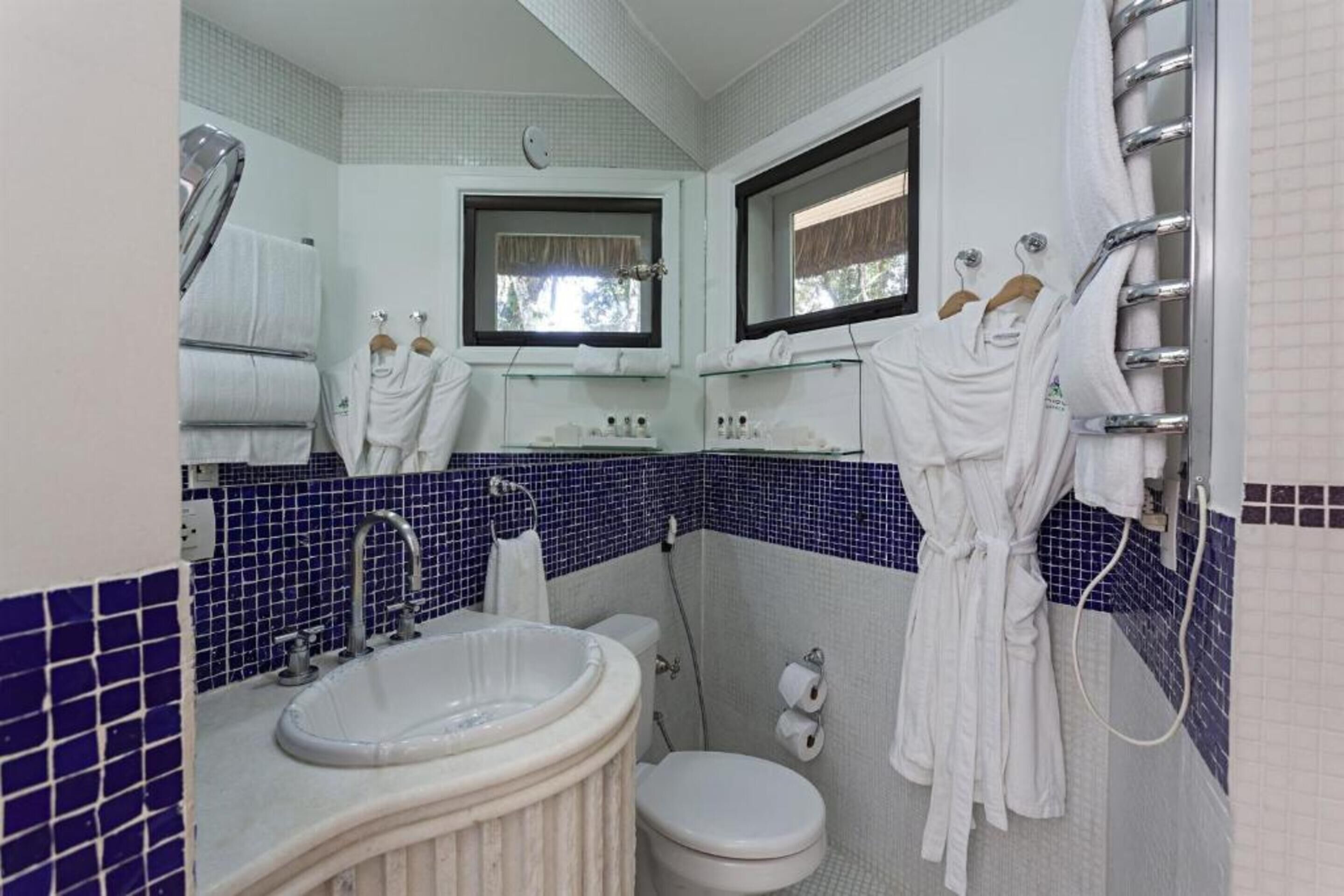 Casa de banho com lavatório, sanita e porta-toalhas.