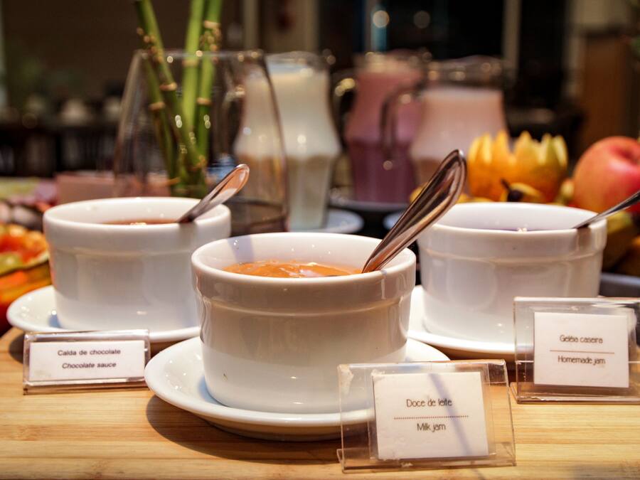 A display of bowls with labels indicating different types of sauces and jams.
