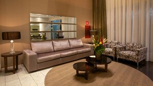 Una sala de estar moderna con sofá, sillones, una mesa de centro y un jarrón decorativo.
