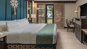 Een hotelkamer met een bed, een bureau met telefoon, een televisie en een zithoek met stoelen.