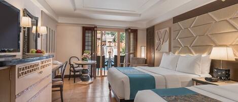 Una habitación de hotel con cama, mesita de noche, lámpara y un escritorio con silla.