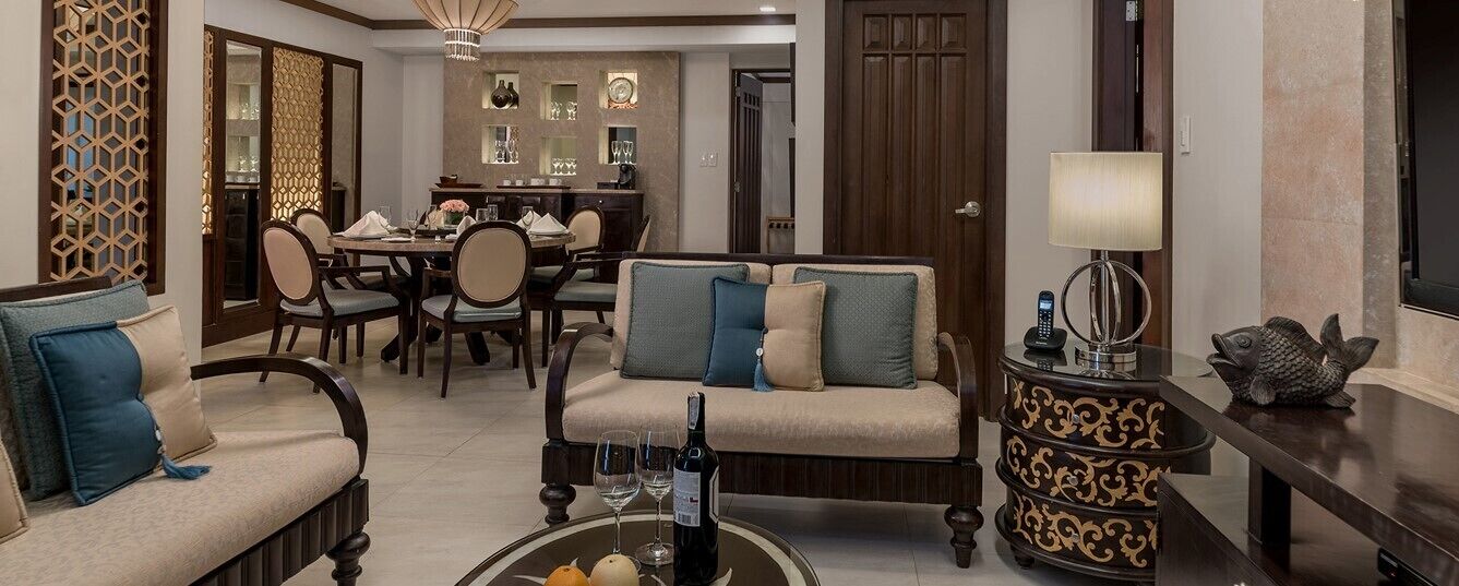 A modern living room with a sofa set, a dining table, and a bar area.