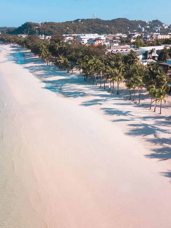 Na praia, areia branca, guarda-sóis, toalhas de praia