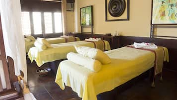 Two single beds with neatly arranged pillows and towels, a classic aesthetic, and framed artwork adorn this traditional hotel room.