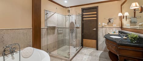A modern bathroom with a glass-enclosed shower, a freestanding bathtub, and a vanity with a sink and mirror.