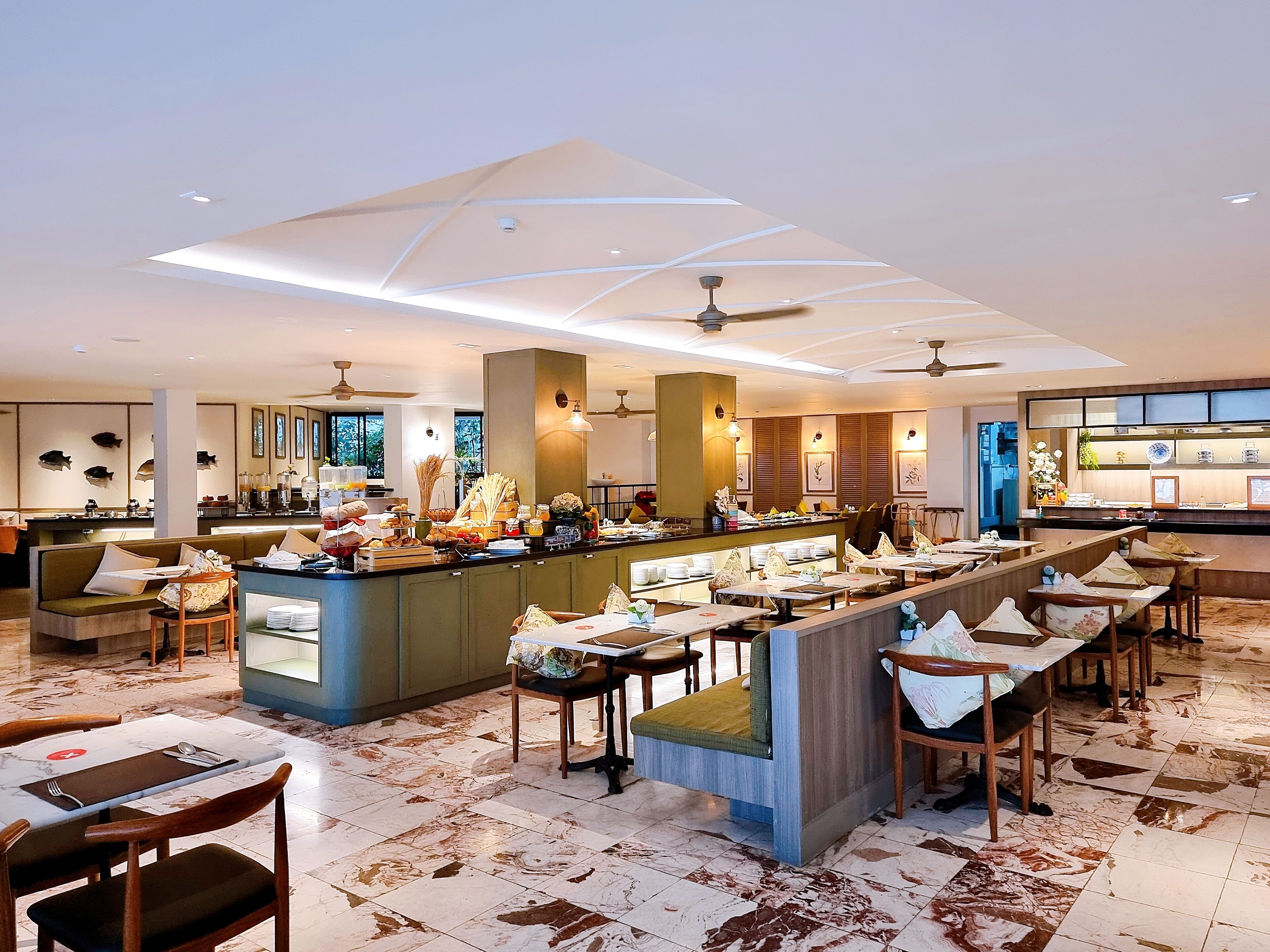 A modern restaurant with a central bar, multiple seating areas, and a marble-tiled floor.
