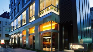 A modern hotel with a glass facade, outdoor seating area, and a sign for Granbell Hotel. - Akasaka Granbell Hotel (Tokyo)