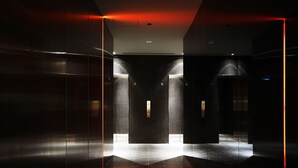 A modern elevator interior with a dark, reflective floor and walls, and a central light feature. - Akasaka Granbell Hotel (Tokyo)