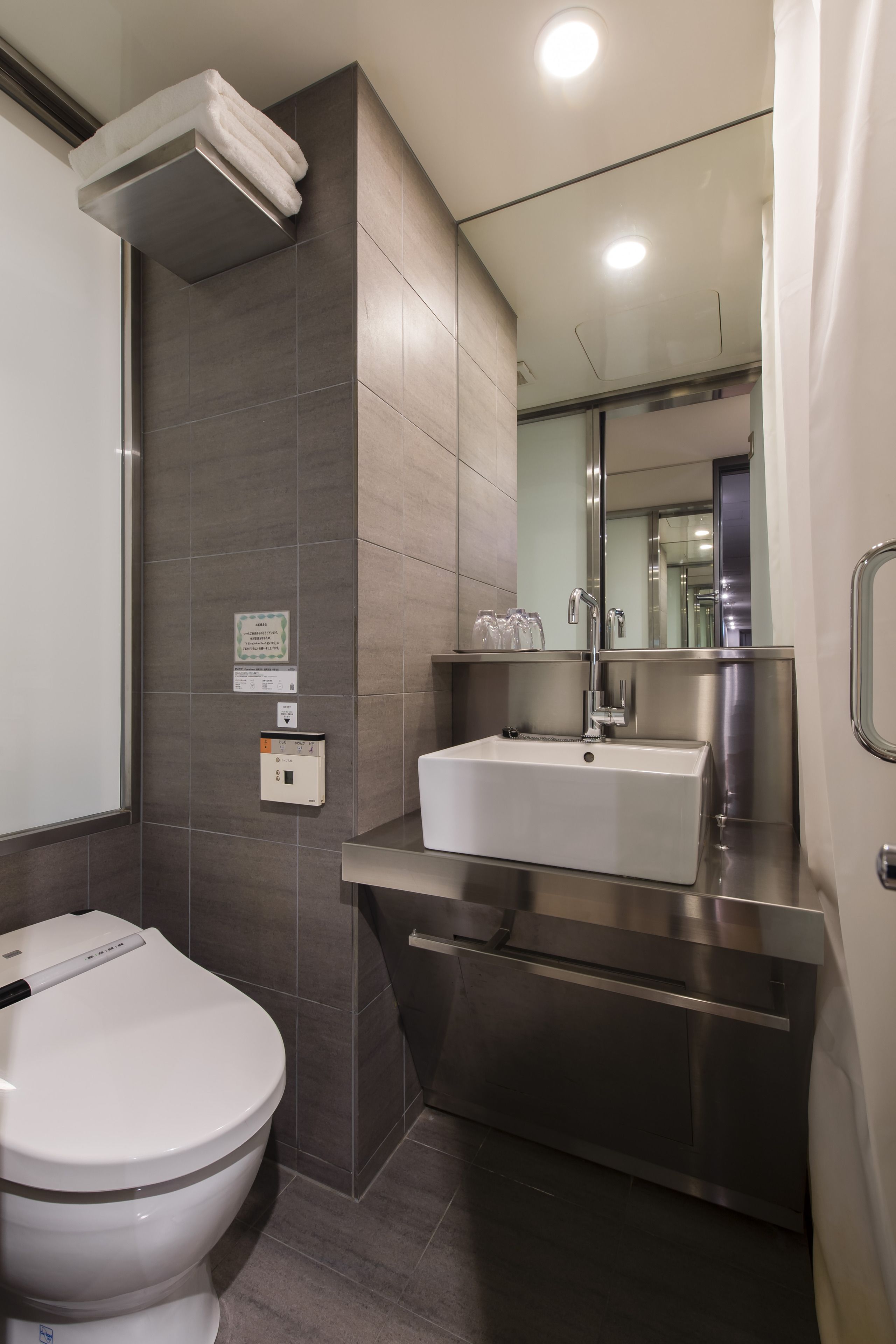 A modern bathroom with a toilet, a sink, and a mirror.