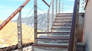 Una escalera con barandillas de metal y escalones de madera que conducen a un nivel superior.