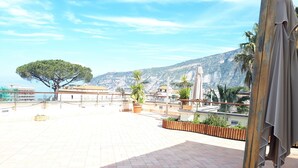 Una terraza en la azotea con vistas al mar y a las montañas.