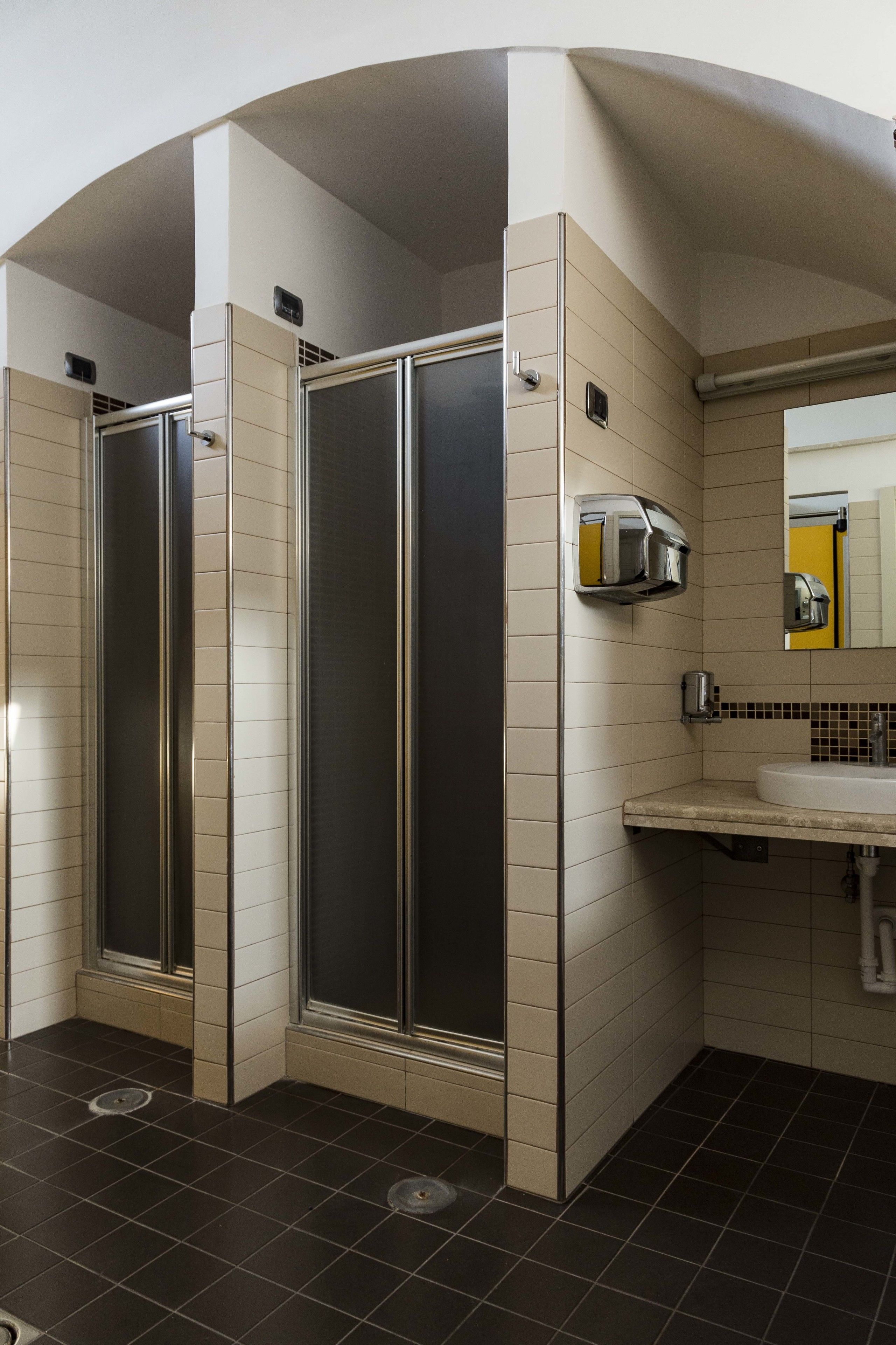 Une salle de bain moderne avec une douche à parois incurvées, un lavabo et un miroir.