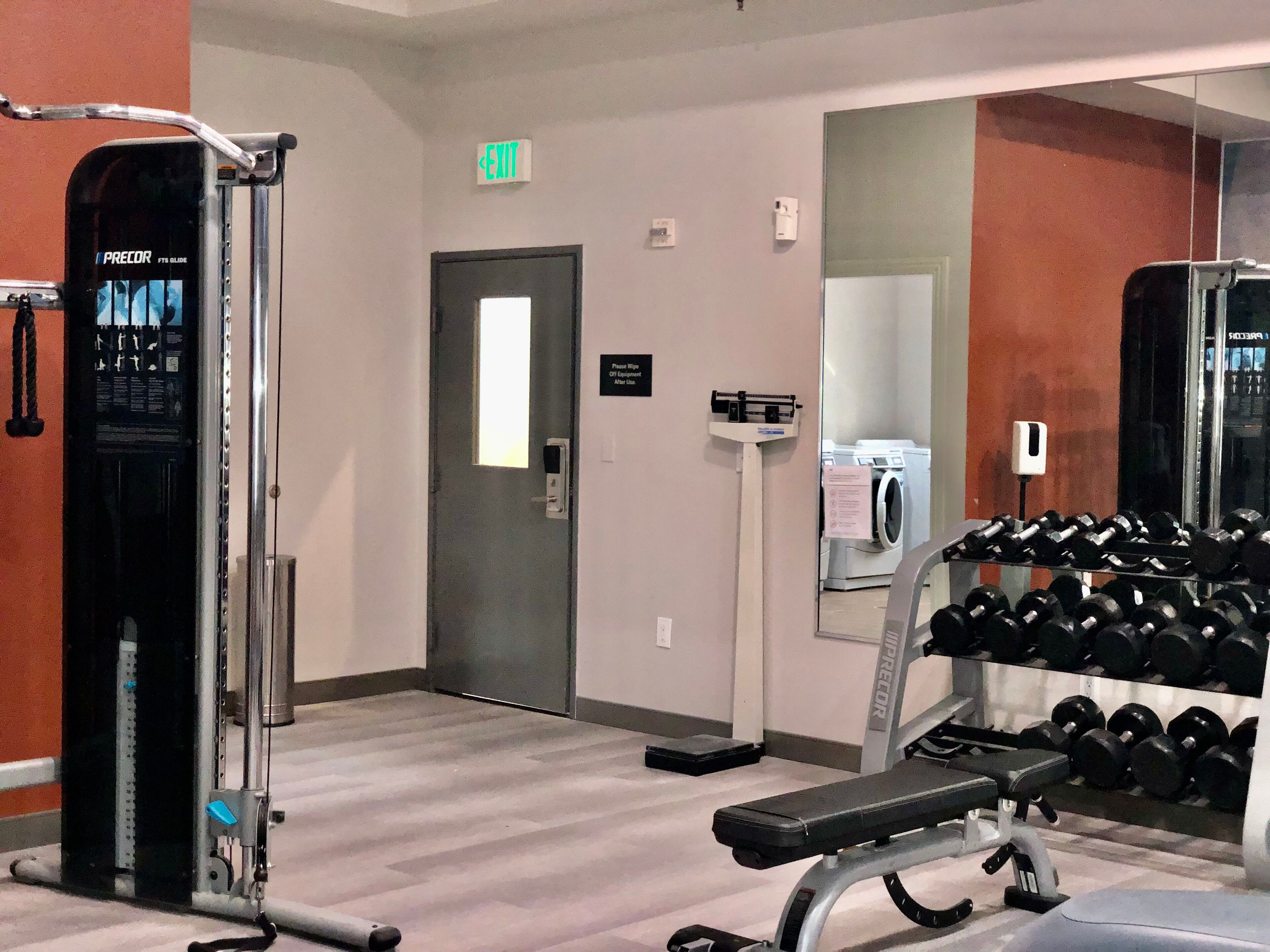 Une salle de sport équipée de machines d’exercice, d’un banc et d’un porte-haltères.