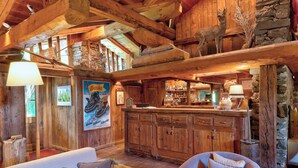 Un interior rústico de madera con barra, muebles de madera y paredes de piedra.