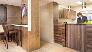Eine moderne Küche mit einer Holztheke, Barhocker und einer Person, die an der Arbeitsplatte steht.