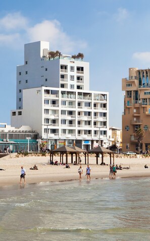 Un hôtel moderne à plusieurs étages, doté de balcons et situé en bord de mer.