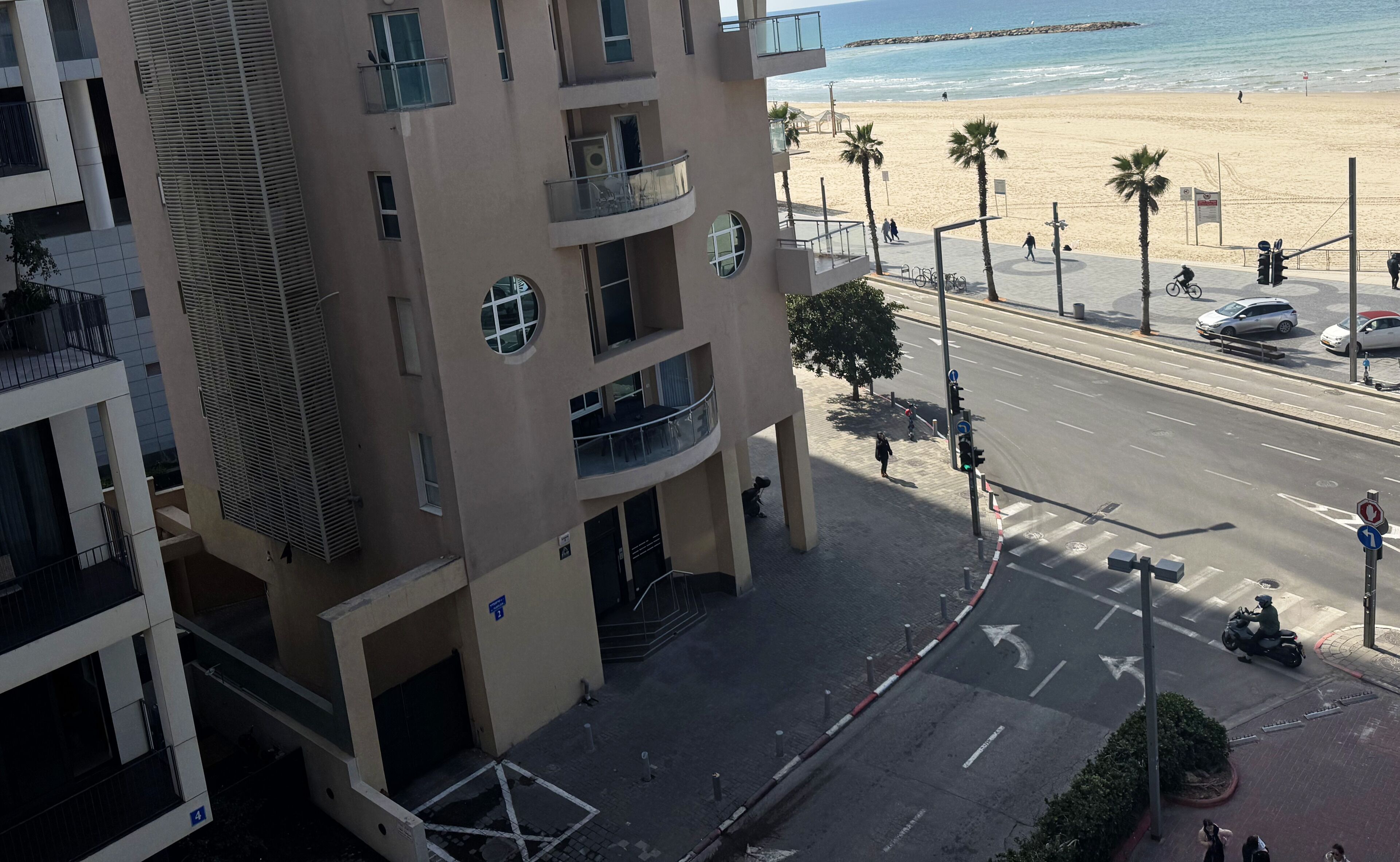 Un immeuble à plusieurs étages doté de balcons donnant sur une plage.