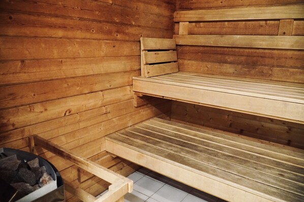 Un sauna avec des bancs en bois et un sol carrelé.